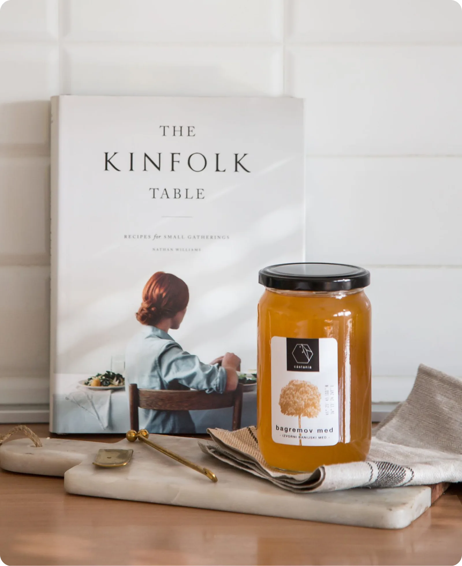 A Castania honey jar beside The Kinfolk Table cookbook.
