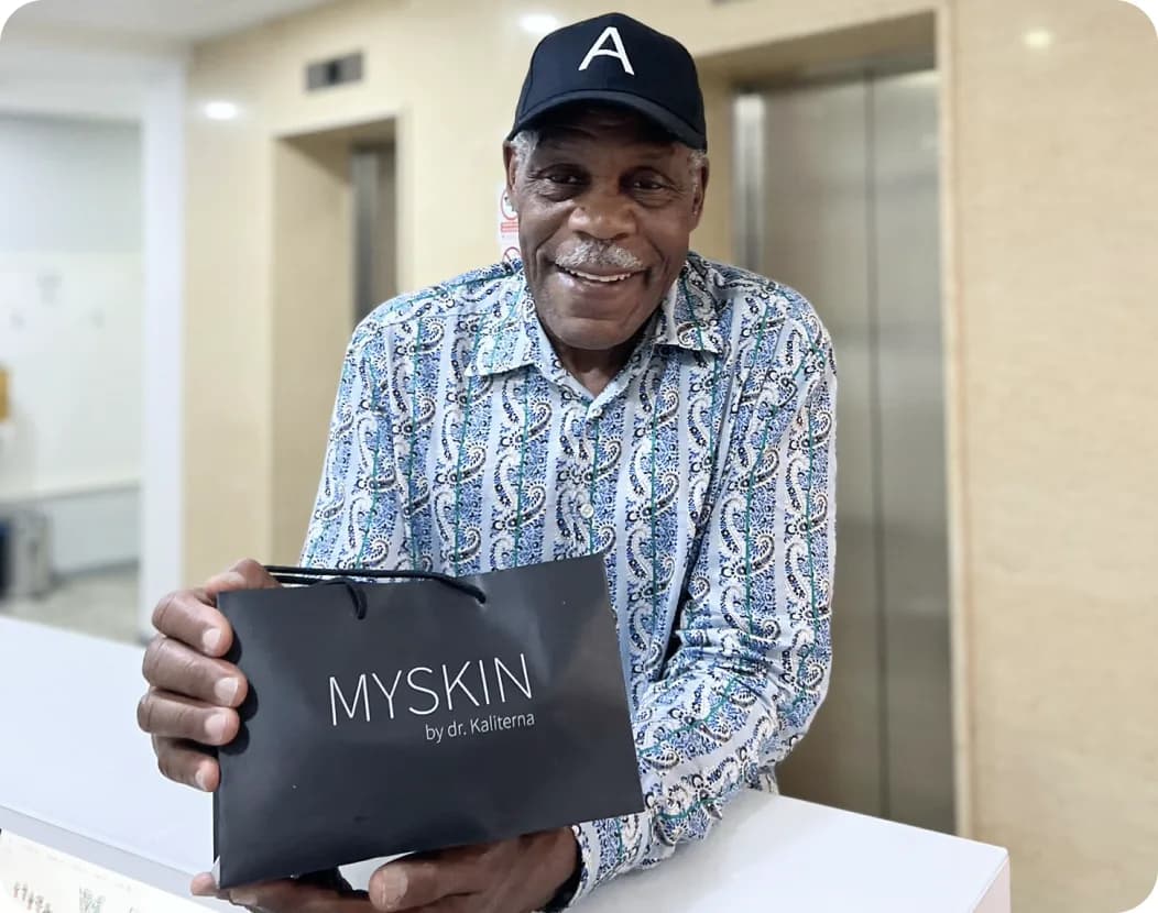 A happy client holding a branded MySkin gift box.