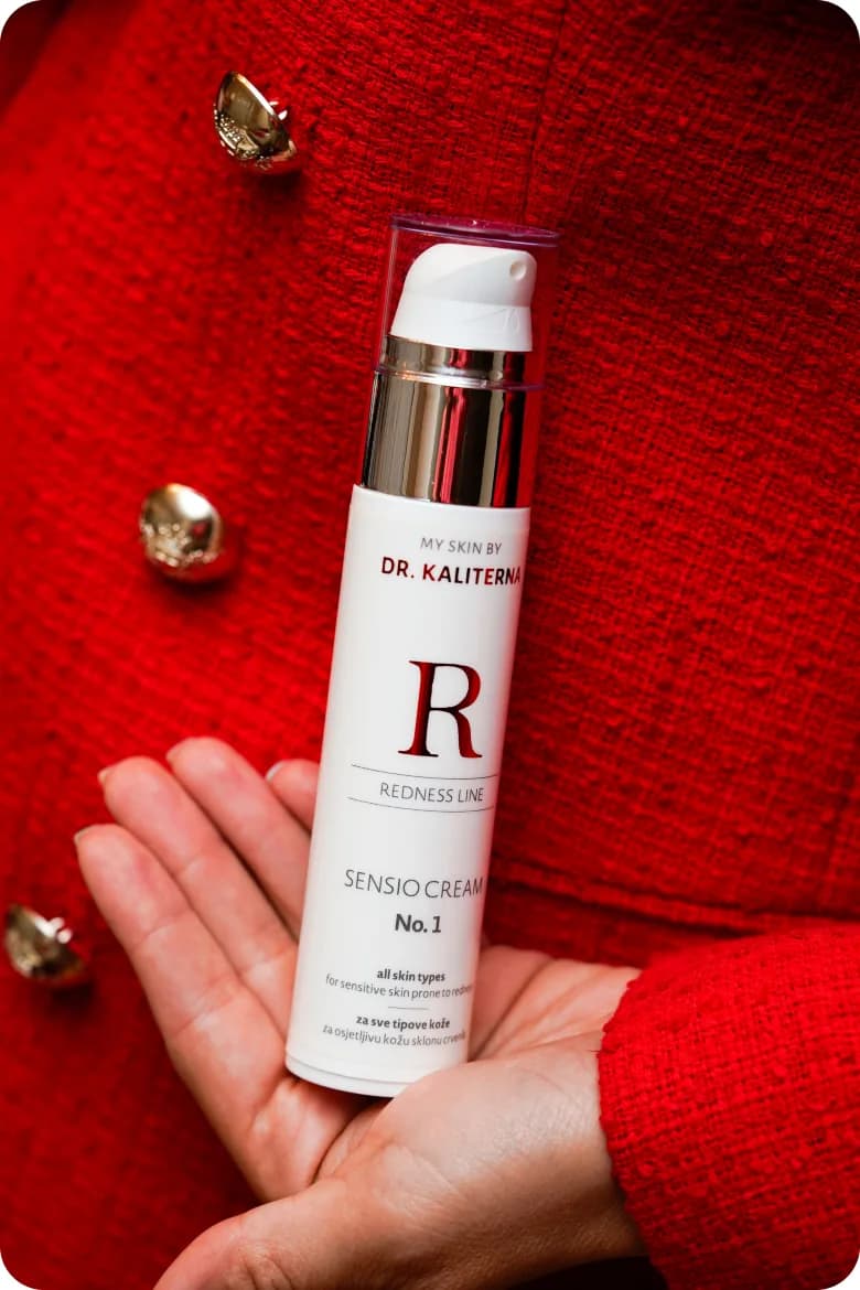 A Dr. Kalterna serum held in hand against a red backdrop.