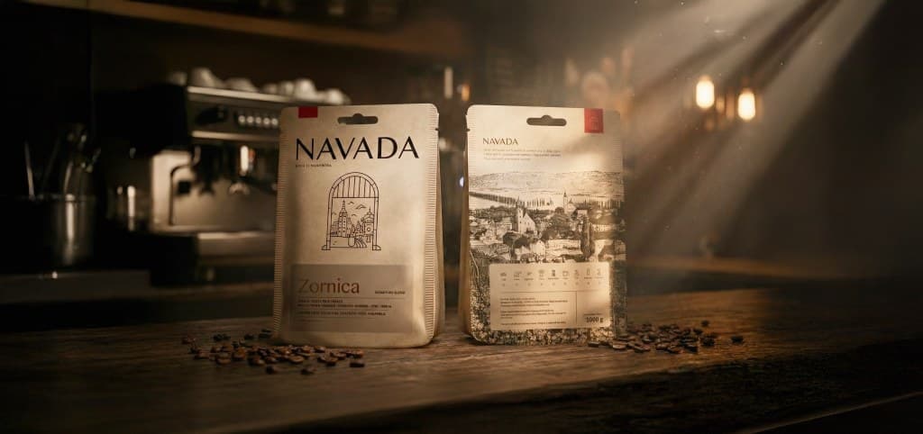NAVADA Zornica coffee bags on a café counter, backlit through the espresso bar.
