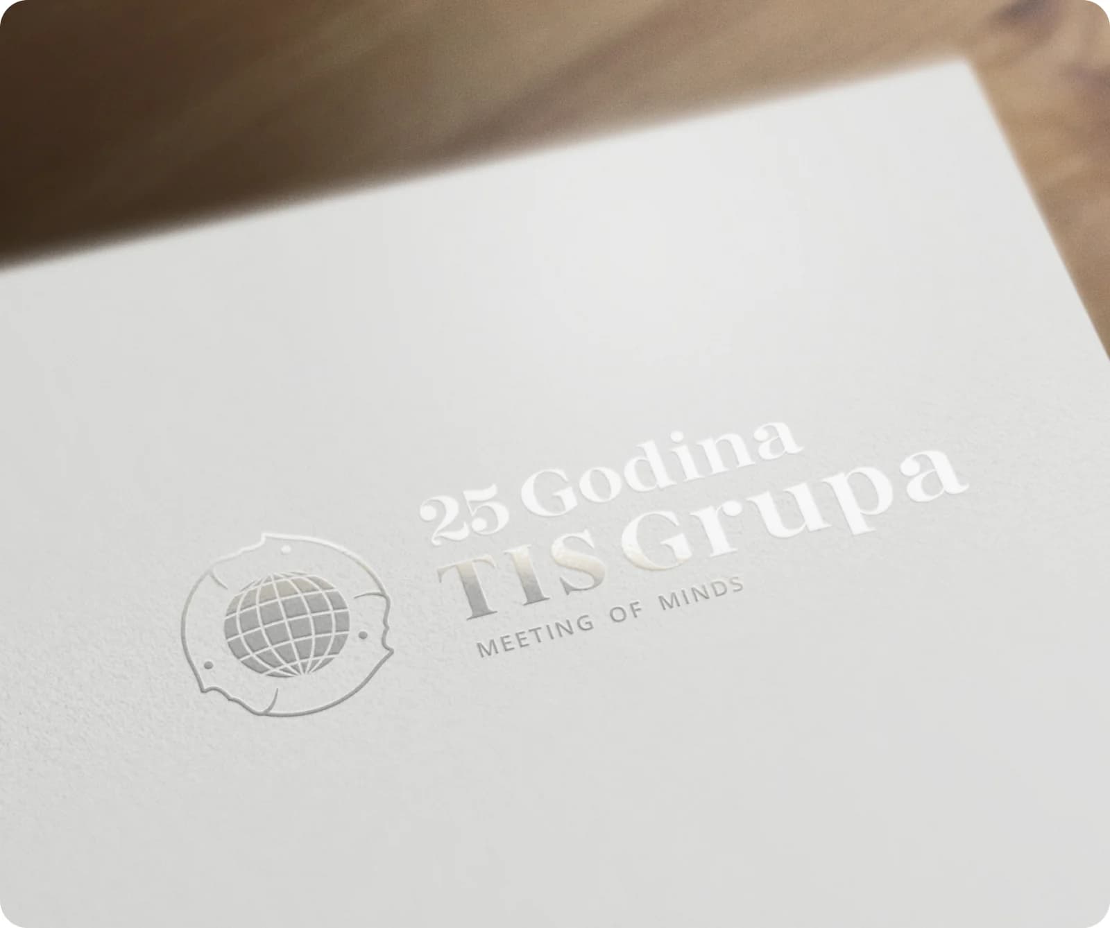The 25 Godina TIS Grupa anniversary logo embossed on white paper.